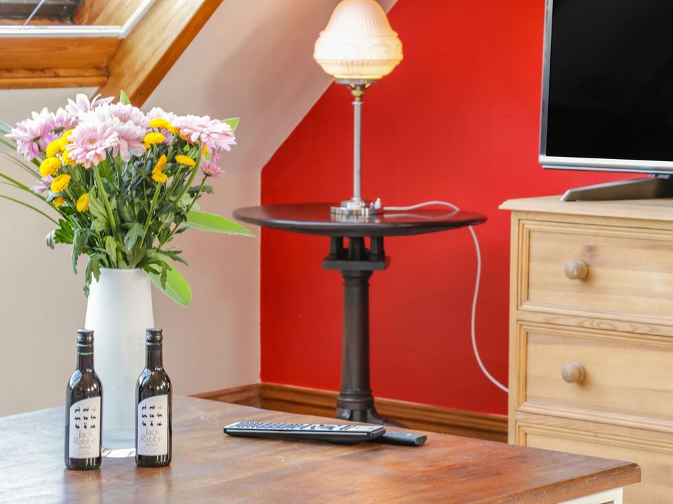 A living room with flowers and a lamp on a side table at Atelier in Bridlington