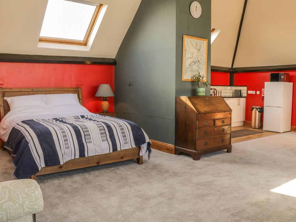 A bedroom with a bed and kitchen area at Atelier in Bridlington