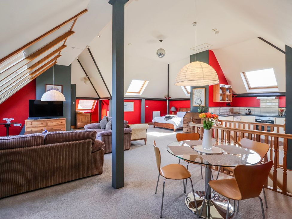 A living room with sofas and a kitchen area at Atelier in Bridlington