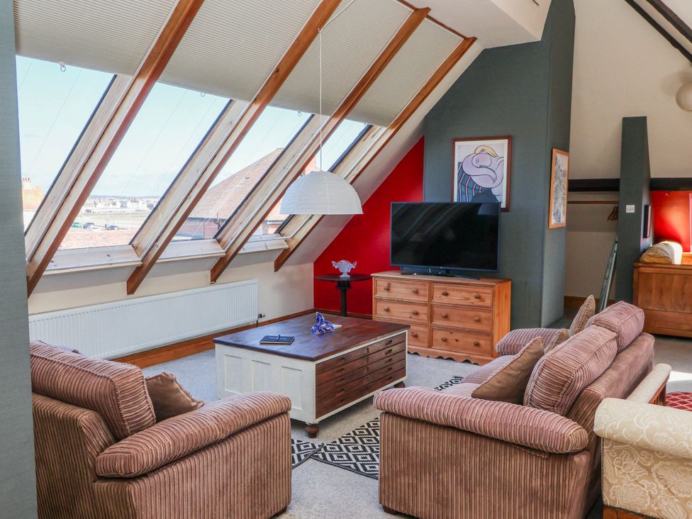 A living room with a sofa, coffee table, and television at Atelier in Bridlington