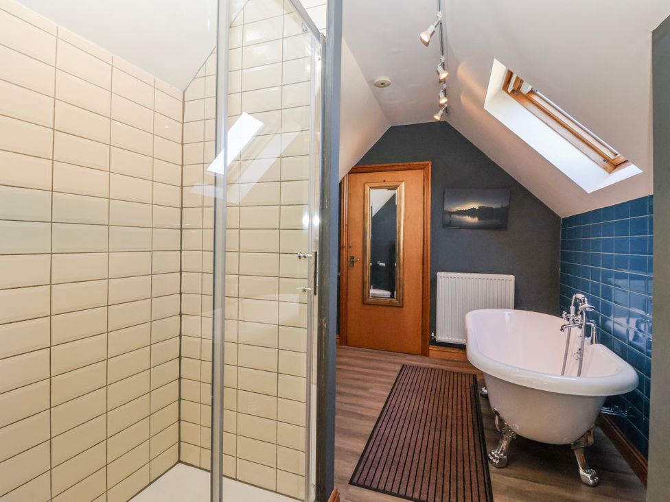 A bathroom with a shower, a bathtub, and a radiator at Atelier in Bridlington