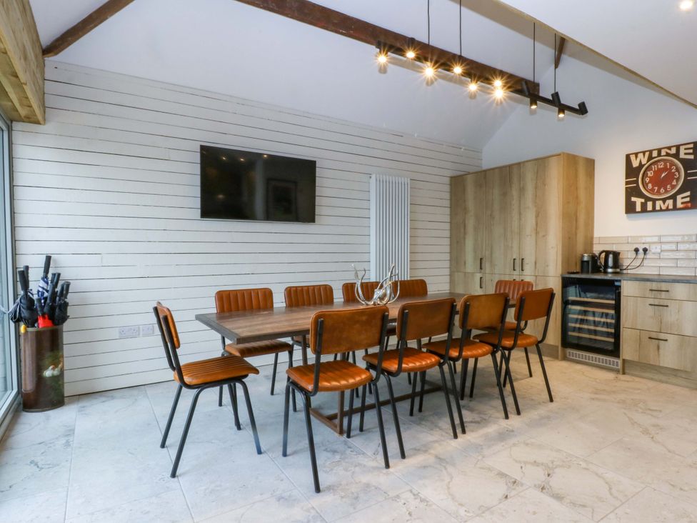 A dining room with a large table and chairs at Gowan Brae Criccieth