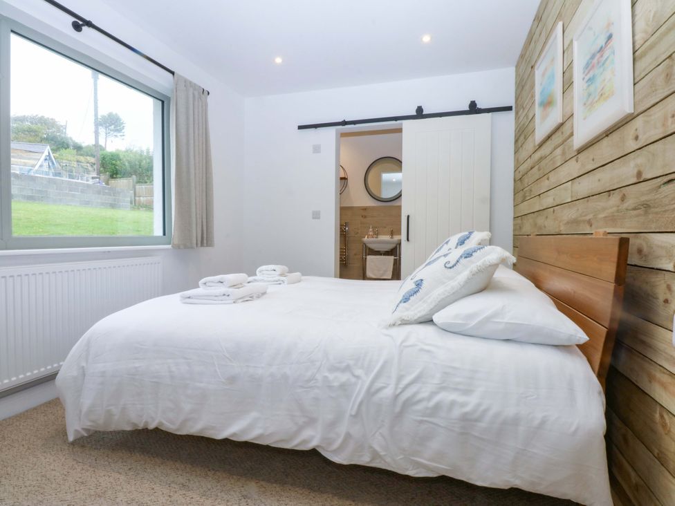A bedroom with a bed and adjoining bathroom at Gowan Brae in Criccieth