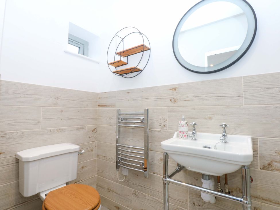 A bathroom with a toilet and a sink at Gowan Brae in Criccieth
