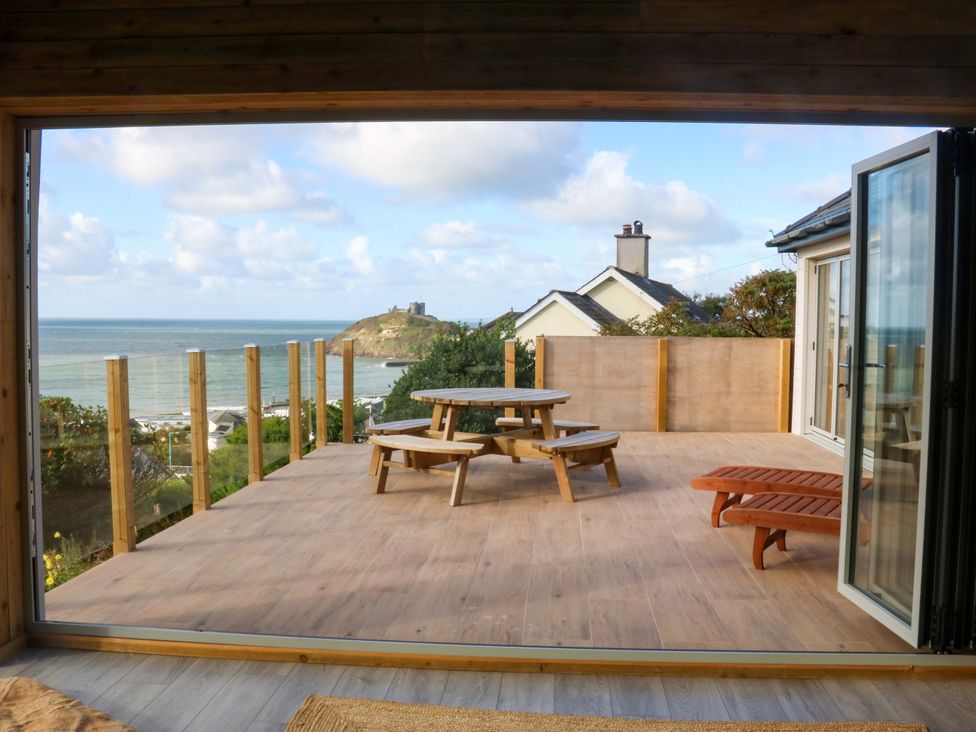 An outdoor seating area with a table and benches at Gowan Brae in Criccieth
