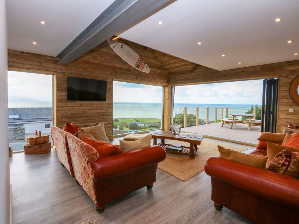 A living room with a coffee table and television at Gowan Brae in Criccieth