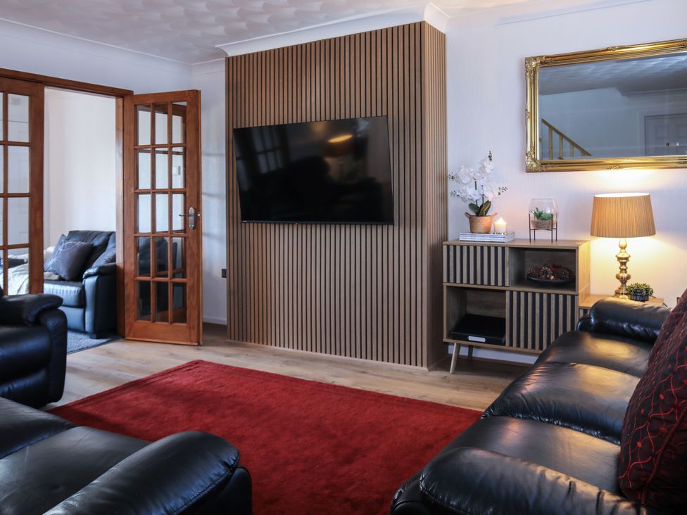 A living room with a television and a sofa at Penrhos Walks Holyhead