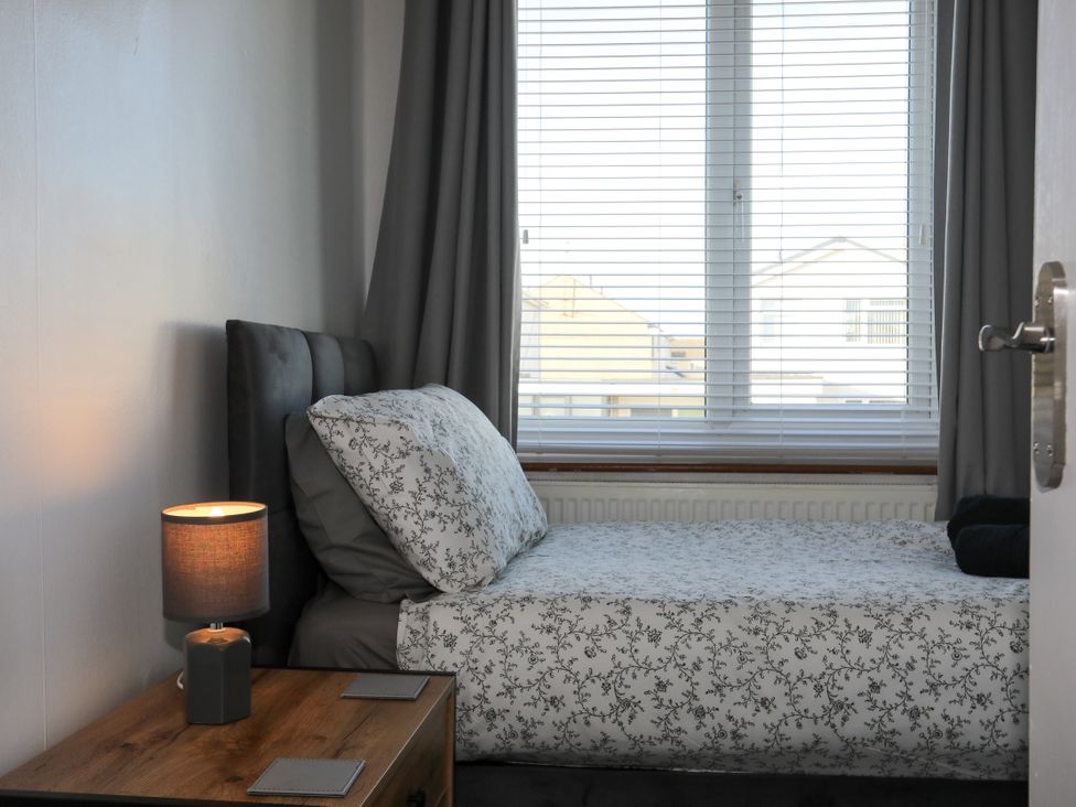A bedroom with a bed and lamp at Penrhos Walks in Holyhead