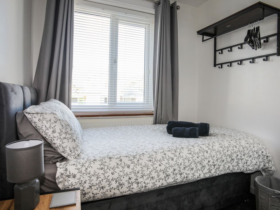A bedroom with a bed and window at Penrhos Walks in Holyhead
