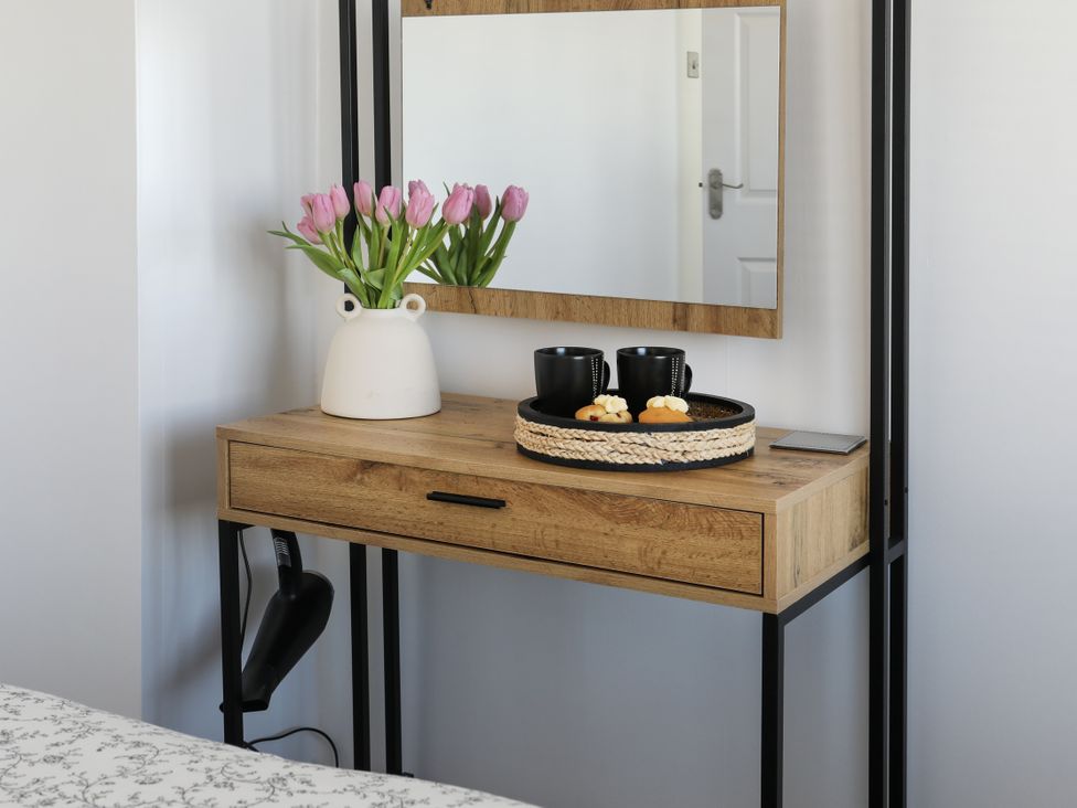 A table with a vase of flowers and cups in Penrhos Walks in Holyhead