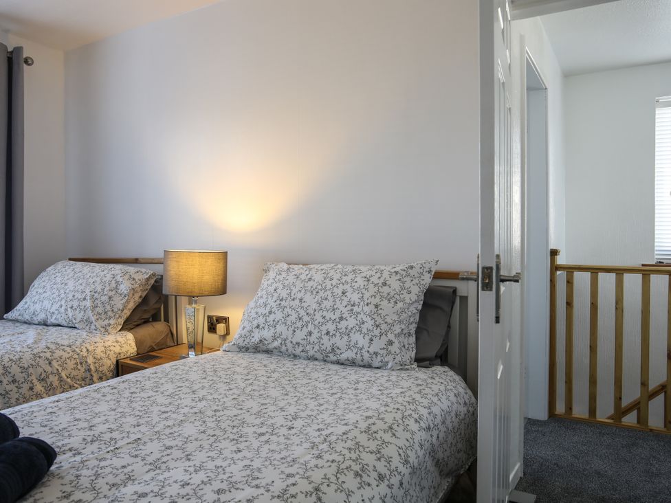A bedroom with two beds and a lamp at Penrhos Walks in Holyhead
