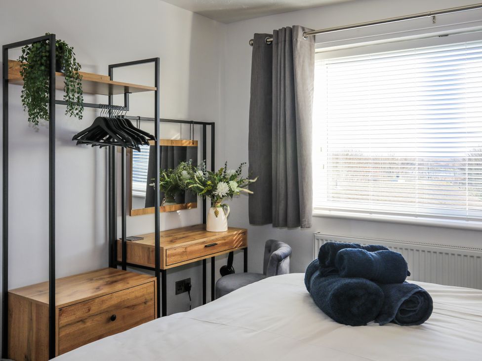 A bedroom with a dresser and mirror at Penrhos Walks Holyhead