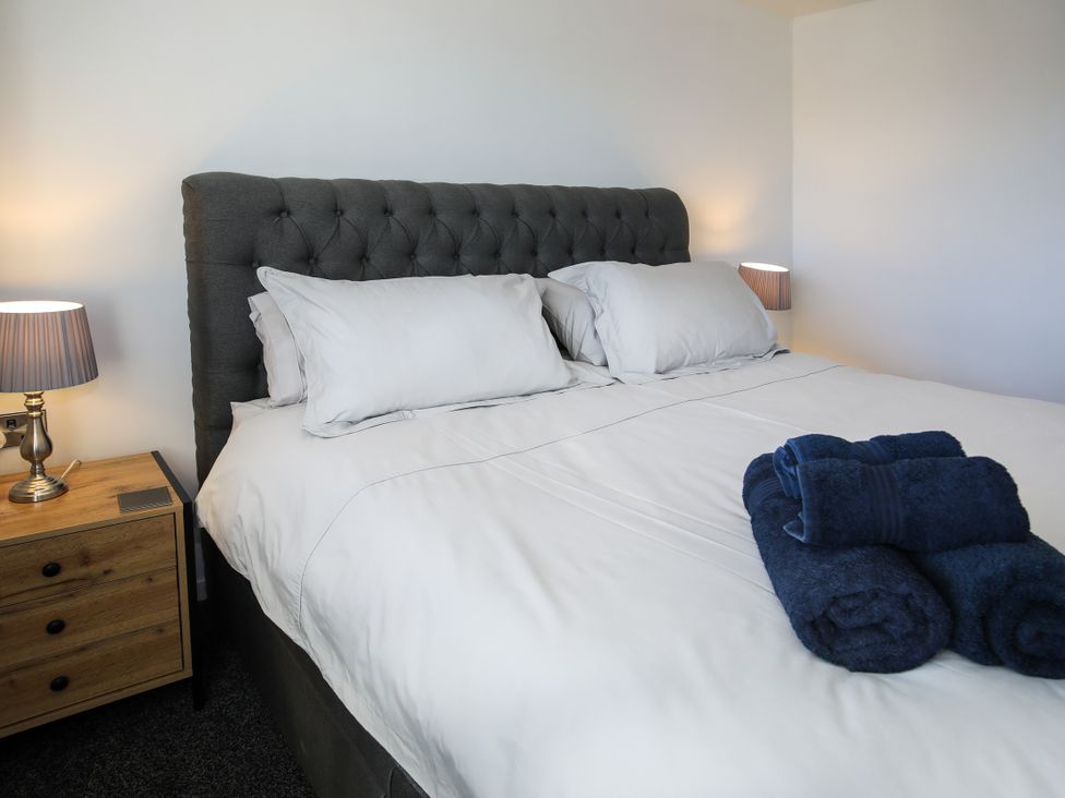 A bedroom with a bed and bedside table at Penrhos Walks Holyhead