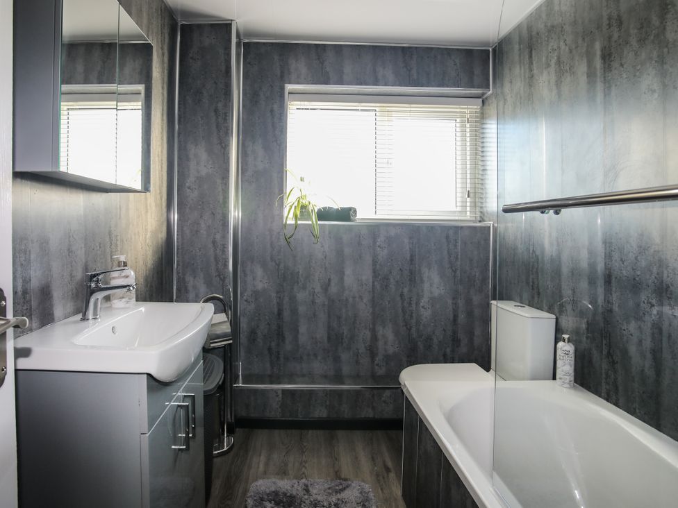 A bathroom with a bathtub, sink, and toilet at Penrhos Walks Holyhead