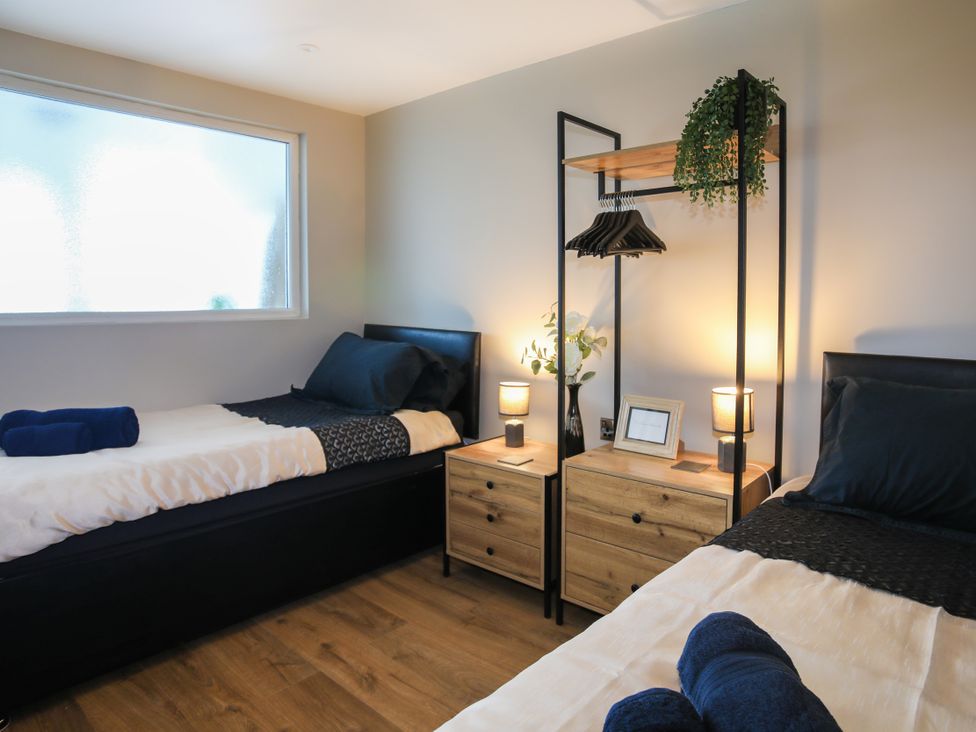 A bedroom with two beds and nightstands at Penrhos Walks in Holyhead