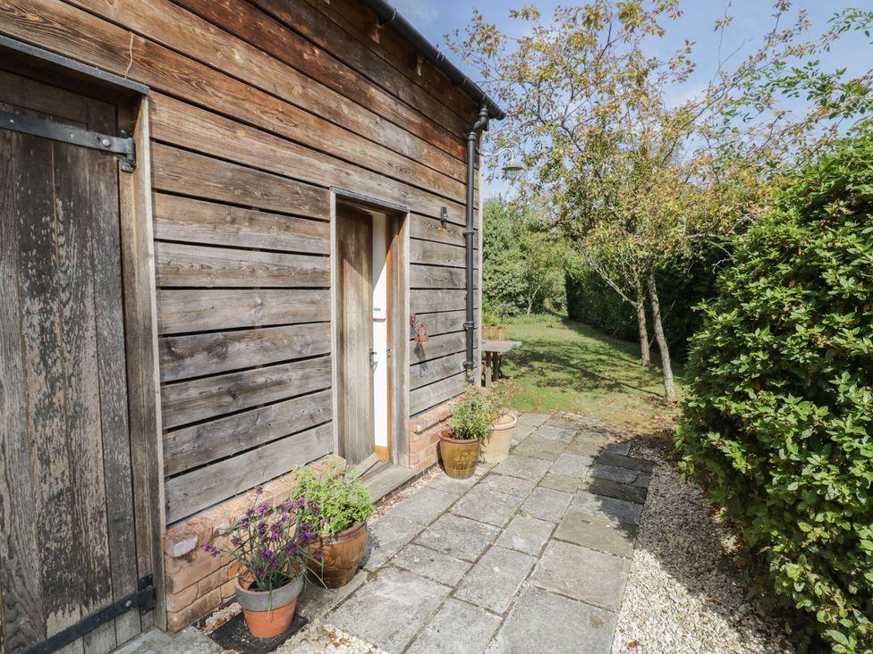 An outdoor space with a wooden wall and pathway at The Shed in Stratford-upon-Avon
