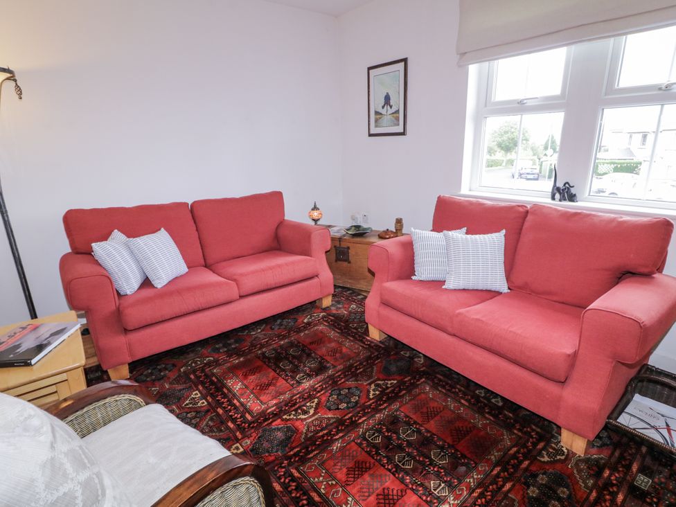 A living room with two red sofas and a wooden table at Burna in Letterkenny