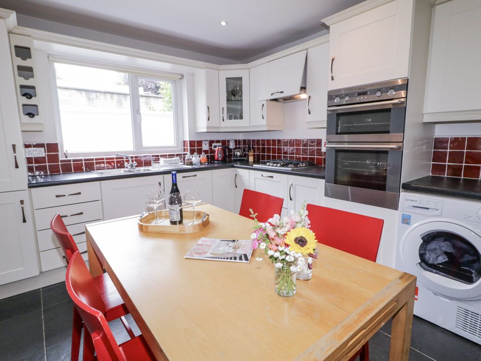 A kitchen with a dining table and red chairs at Burna in Letterkenny