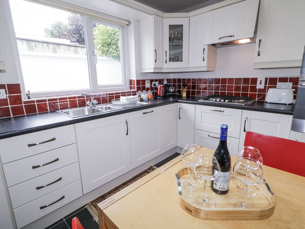 A kitchen with a sink and wine glasses on a table at Burna in Letterkenny
