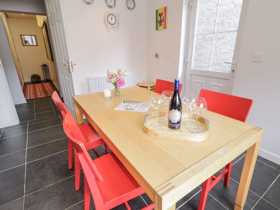 A dining room with a table and red chairs at Burna in Letterkenny