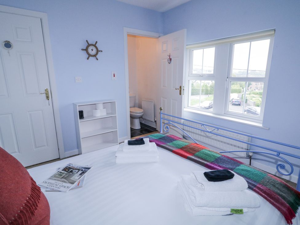 A bedroom with a bed and a view to the bathroom at Burna in Letterkenny