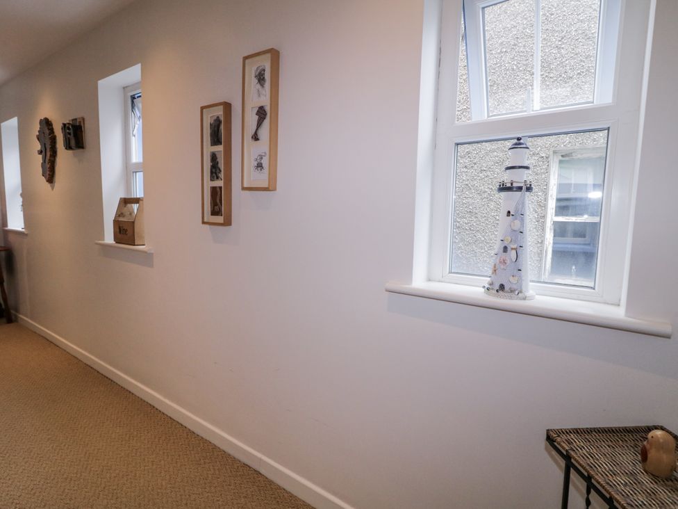 A hallway with a decorative lighthouse and photo frames at Burna in Letterkenny