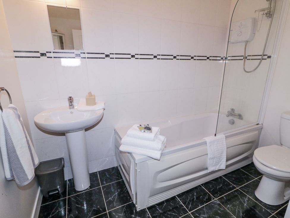 A bathroom with a bathtub, sink, and toilet at Burna in Letterkenny