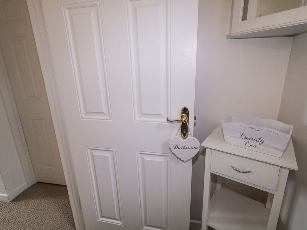 A bathroom door with a sign and a cabinet at Burna in Letterkenny