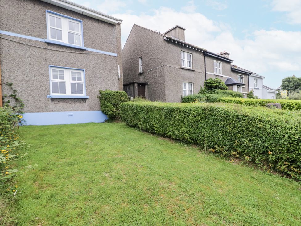 An outdoor view of houses with a hedge and grass at Burna in Letterkenny