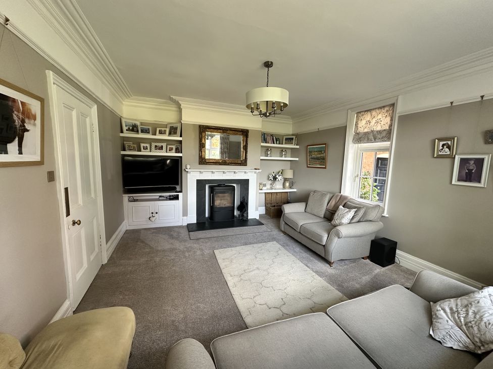 A living room with a television, sofa, and fireplace at The Old Vicarage in 