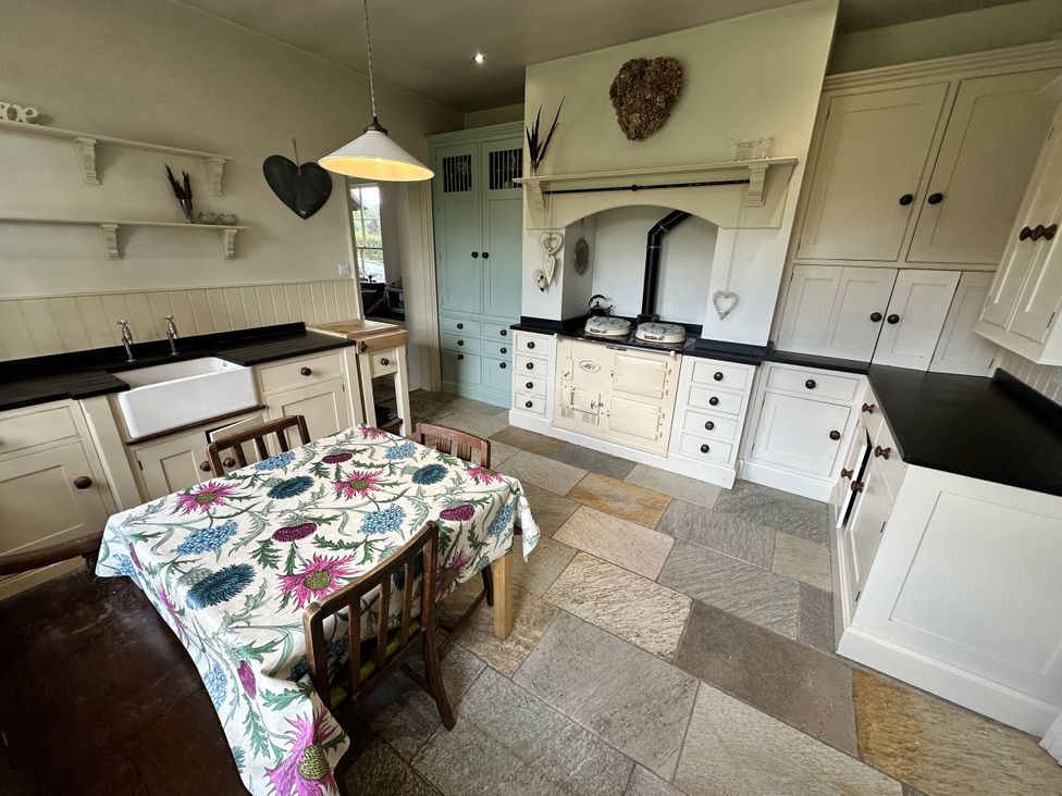 A kitchen with a table and sink at The Old Vicarage in 