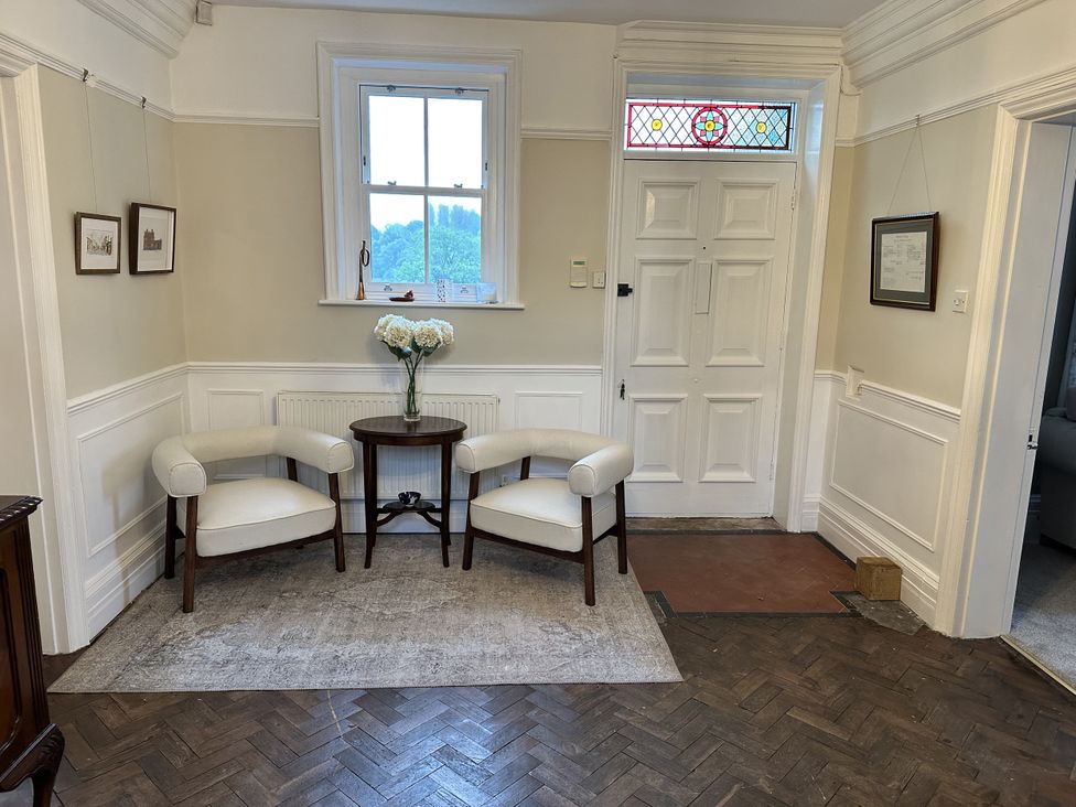 A hallway with chairs and a table at The Old Vicarage