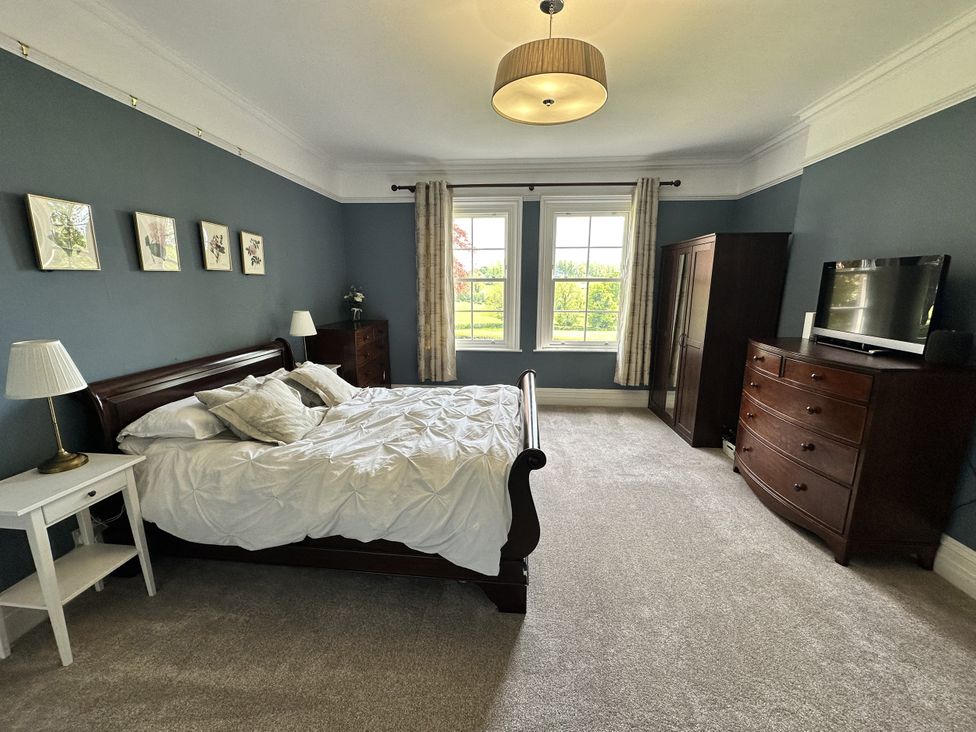 A bedroom with a bed and dresser at The Old Vicarage in 