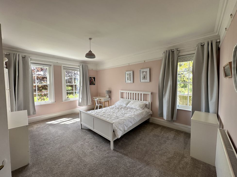 A bedroom with a bed and desk at The Old Vicarage