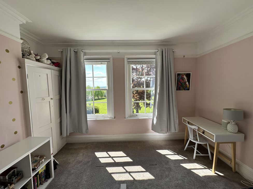 A bedroom with a desk and windows at The Old Vicarage 