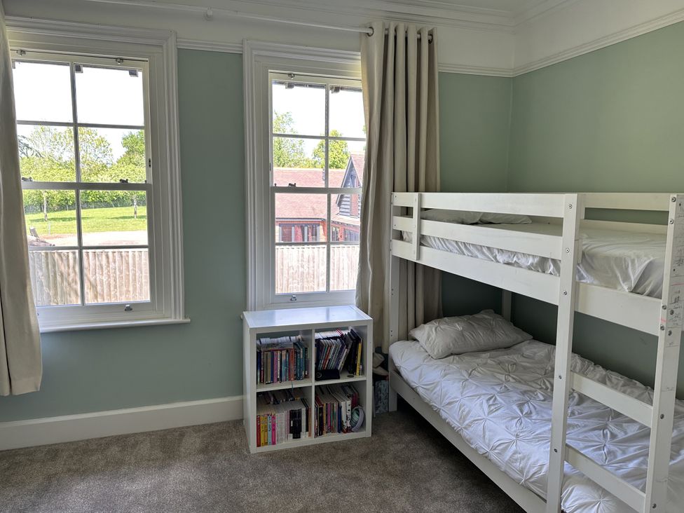 A bedroom with a bunk bed and bookshelf at The Old Vicarage in 