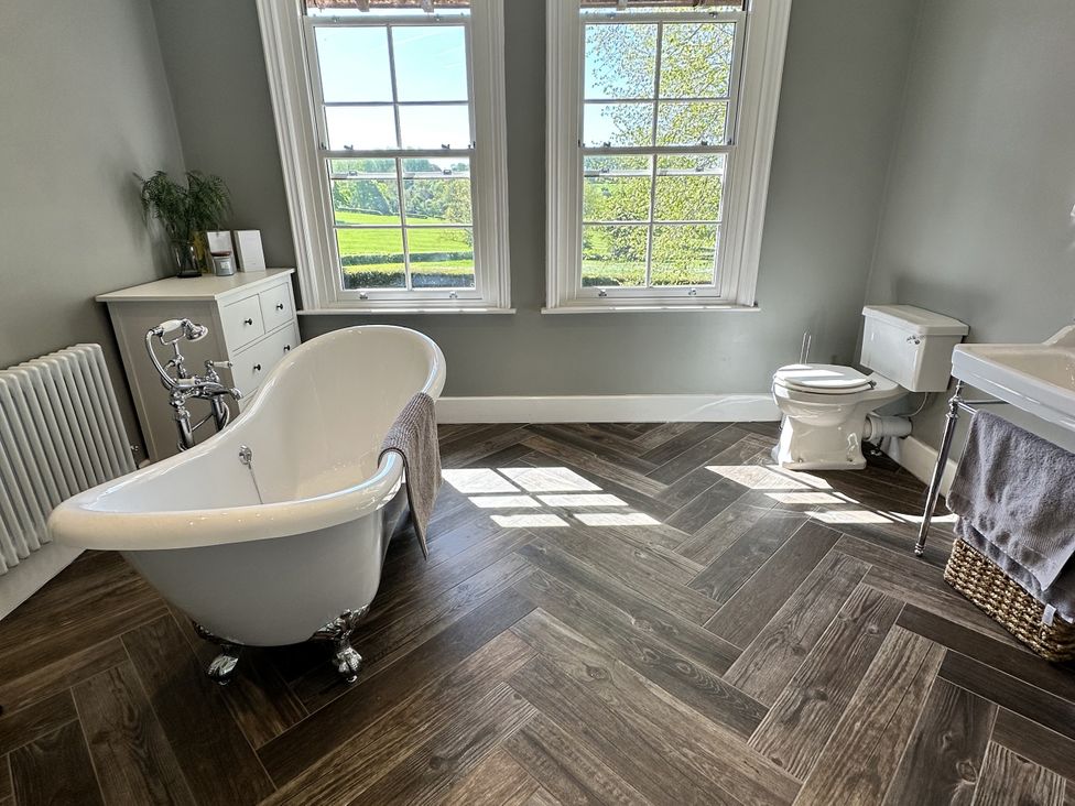 A bathroom with a bathtub, toilet, and sink at The Old Vicarage in 