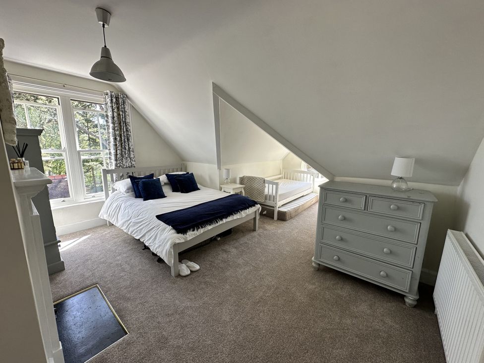 A bedroom with a bed and a crib at The Old Vicarage 