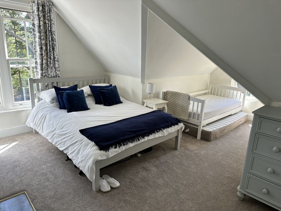 A bedroom with a bed and a crib at The Old Vicarage