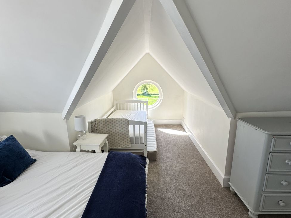 A bedroom with a bed and a toddler bed at The Old Vicarage in 