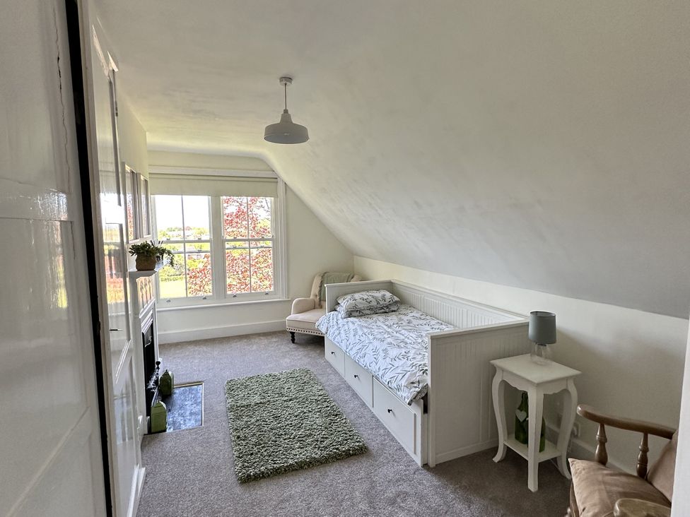 A bedroom with a bed, window, and chair at The Old Vicarage in 