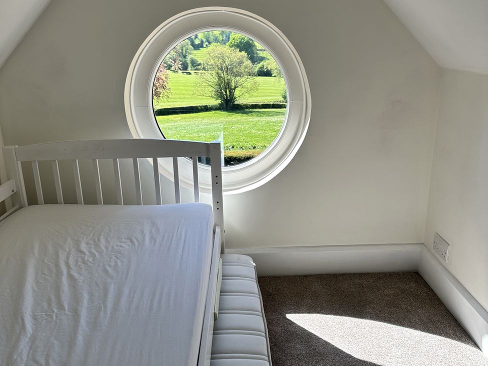 A bedroom with a bed and a circular window at The Old Vicarage 