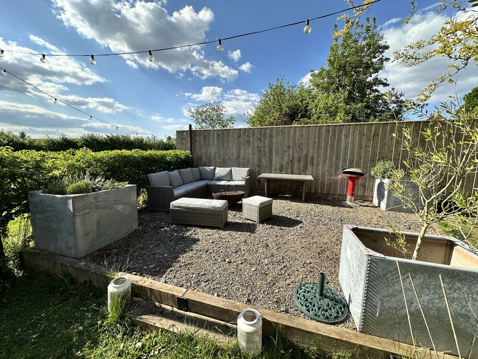 A garden with seating area and planters at The Old Vicarage 
