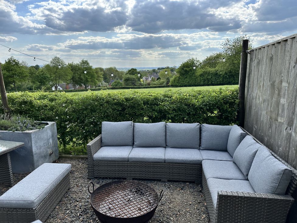 An outdoor seating area with a fire pit and sectional sofa at The Old Vicarage in 