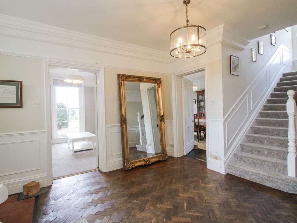 A hallway with a mirror and staircase at The Old Vicarage in Kimbolton near Leominster