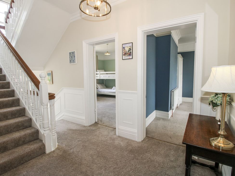 A hallway with a staircase and doorways at The Old Vicarage in Kimbolton near Leominster