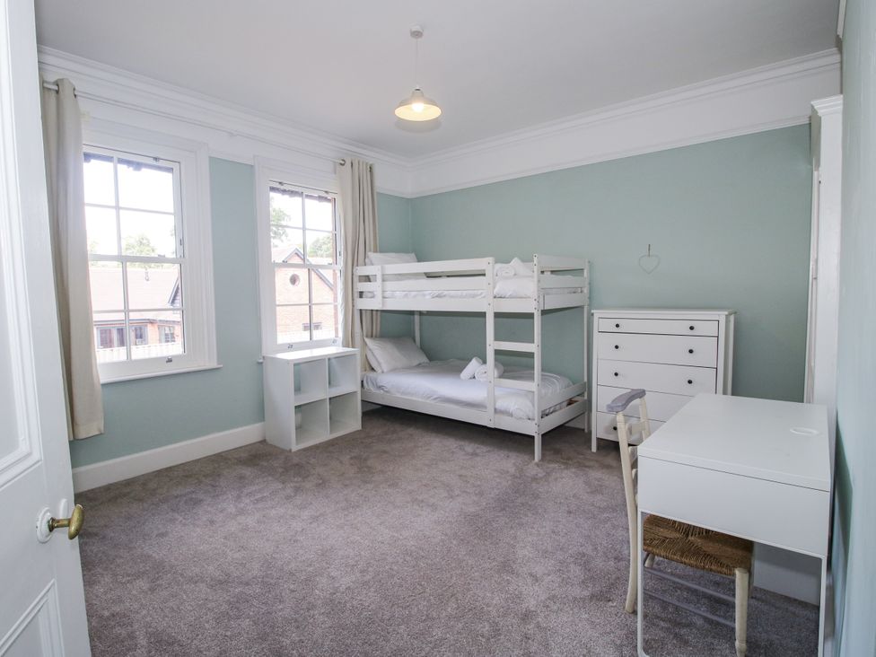 A bedroom with a bunk bed and desk at The Old Vicarage in Kimbolton near Leominster