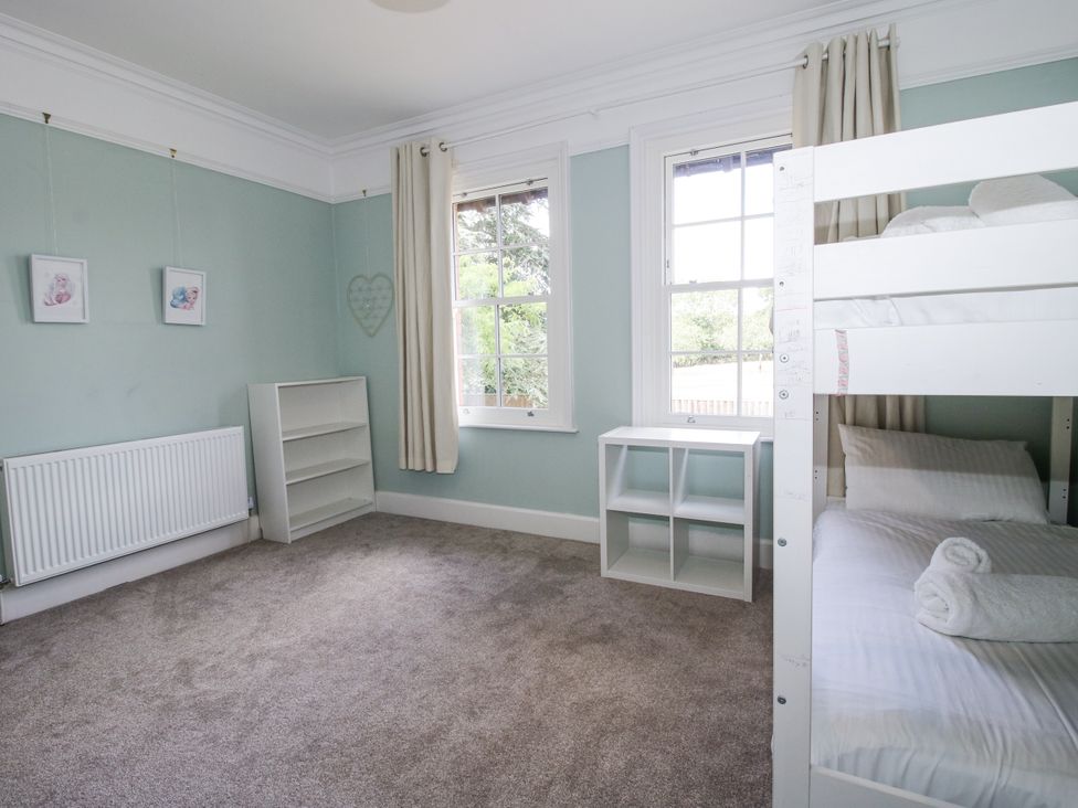 A bedroom with a bunk bed and bookshelf at The Old Vicarage Kimbolton near Leominster