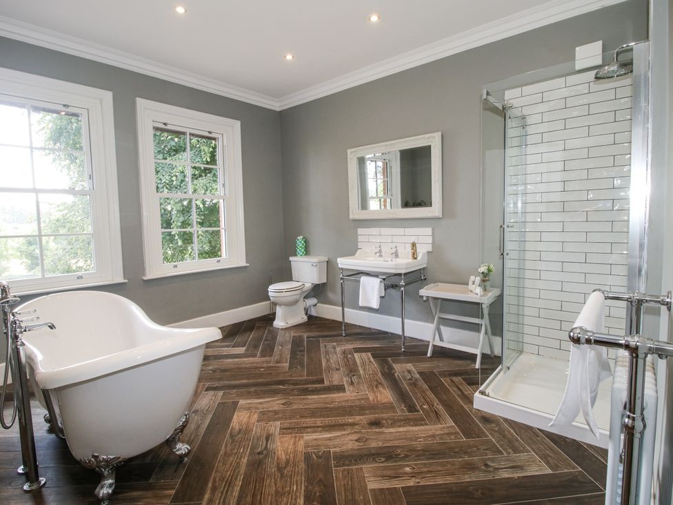 A bathroom with a bathtub, sink, toilet and shower at The Old Vicarage in Kimbolton near Leominster