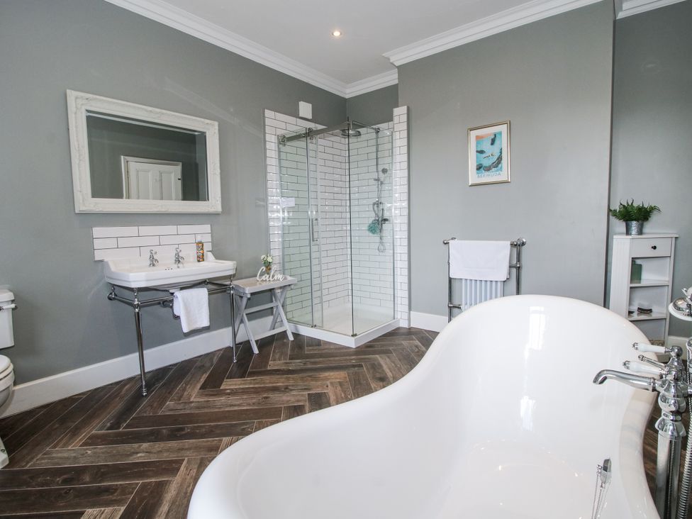 A bathroom with a bathtub and shower enclosure at The Old Vicarage in Kimbolton near Leominster